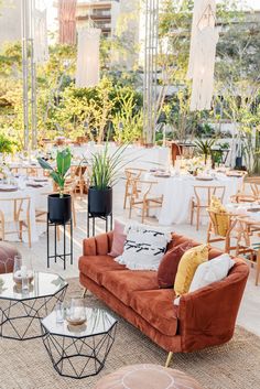 a living room filled with lots of furniture and tables covered in white tablecloths