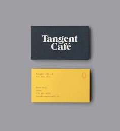 a black and yellow business card sitting on top of a gray surface