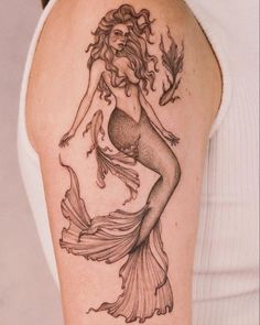 a woman with a mermaid tattoo on her arm