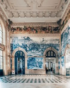 an ornately decorated lobby with checkered flooring and large murals on the walls