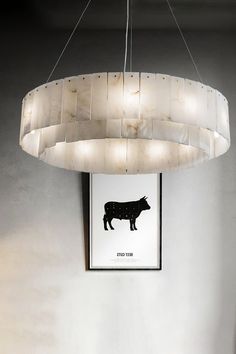 an animal print hangs on the wall above a table and chair in a room with white walls