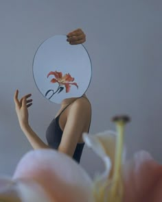 a woman holding up a plate with a flower on it's face and hands