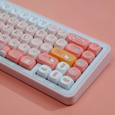 a pink and white computer keyboard with hello kitty keys on it's back side