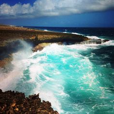 the ocean waves are crashing against the rocky shore