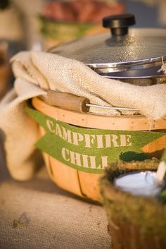 a tea kettle sitting on top of a table next to a basket filled with food