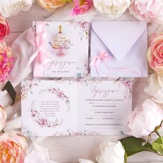 the wedding stationery is surrounded by pink and white flowers