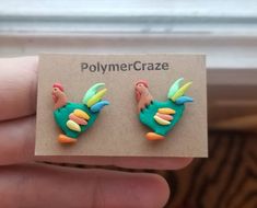 a pair of polymer earrings in the shape of a bird