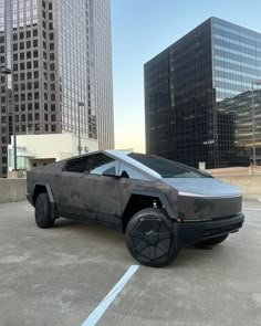 a futuristic car parked in a parking lot next to tall buildings