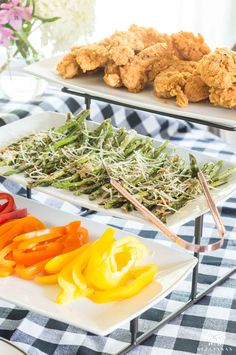 three trays filled with different types of food on top of a checkered table cloth