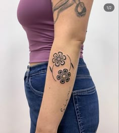 a woman with a flower tattoo on her left arm and the other half of her arm