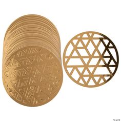 a stack of gold coasters next to each other on a white background with an intricate design