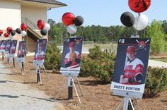 a bunch of signs with baseball players on them in front of a building and some balloons