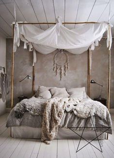 a bed with white sheets, pillows and blankets on top of it in a room