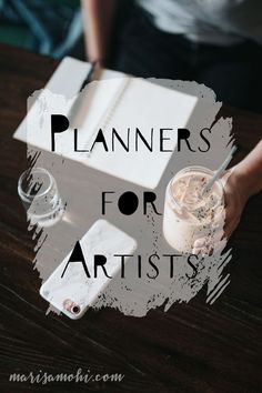 a person sitting at a table with a book and drink in front of them that says planners for artists