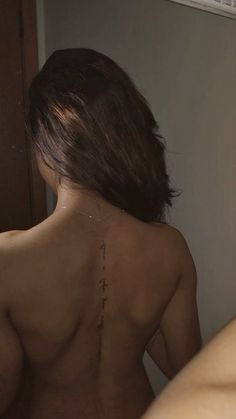 the back of a woman's naked body in front of a mirror