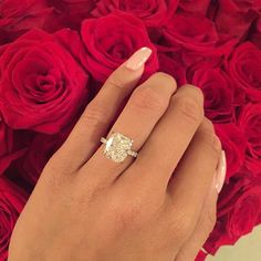 a woman's hand with a ring on it and roses in front of her