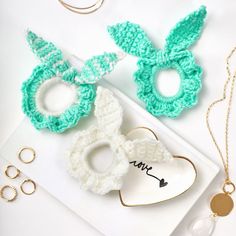 crocheted bunny ears and other accessories are laid out on a white table top