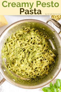 creamy pesto pasta in a pan with basil and parmesan cheese on the side