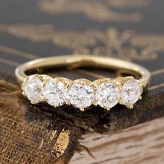 three stone ring sitting on top of an old book