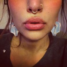 a woman with piercings on her nose and nose ring in front of her face