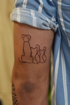 a person with a dog tattoo on their arm and leg, showing the outline of two dogs