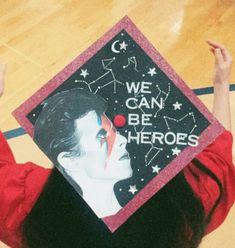 a woman wearing a graduation cap that says we can be heros