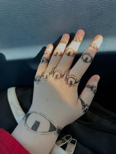 a woman's hand with tattoos on it in the back seat of a car