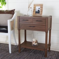 a wooden table sitting next to a white chair on top of a carpeted floor