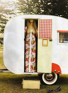 a woman standing in the doorway of a trailer