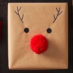 a gift wrapped in brown paper with a red nose and nose on top of it