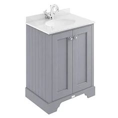 a white sink sitting next to a gray cabinet