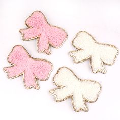 three small pink and white bows on a white background