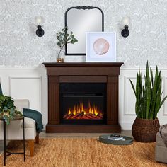 a living room with a fire place and two chairs in front of the fireplace that is lit