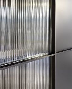 the side of a building with metal slats on it's glass doors and windows