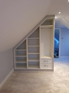 an attic bedroom with built - in shelving and closet space for storing clothes, books or other items