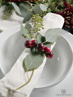 a white plate topped with berries and greenery