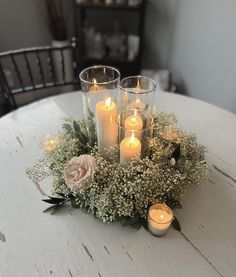 some candles are sitting on a table with flowers