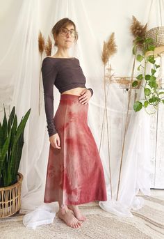 a woman standing in front of a white backdrop wearing a red skirt and black crop top