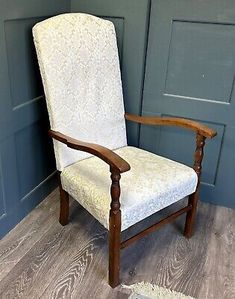 a white chair sitting on top of a wooden floor next to a blue painted wall