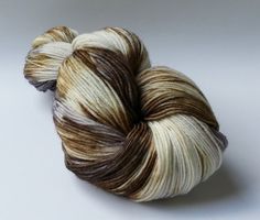 a skein of brown and white yarn on a white surface