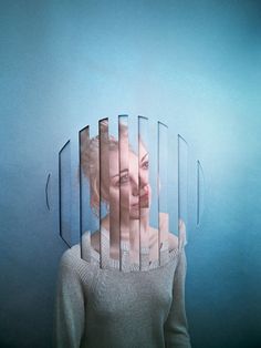 a woman standing in front of a blue wall with multiple lines on it's face