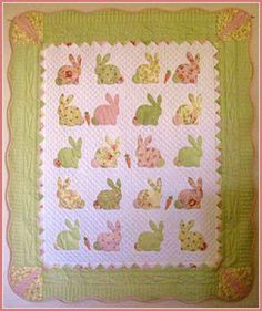 a quilted wall hanging with rabbits on it