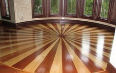 an empty room with wooden floors and windows