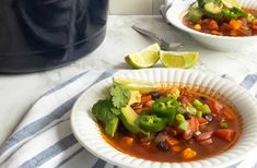 two white bowls filled with chili and vegetables