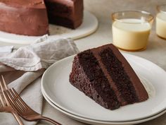 a slice of chocolate cake on a white plate next to a fork and glass of milk