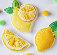 three felt lemons with green leaves on them