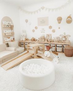 a room filled with lots of furniture and decor in white colors on the walls, along with wooden shelves