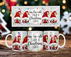 three coffee mugs with santa hats on them sitting in front of a christmas tree