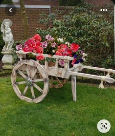 a wooden wagon filled with flowers sitting in the grass