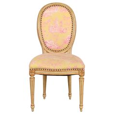 an ornately decorated chair with pink and gold upholstered fabric on the back